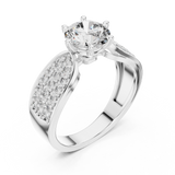 Close-up view of a white gold split shank engagement ring featuring a round lab-grown diamond center stone and pavé-set diamond shoulders on a transparent background.