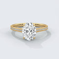 Gold ring with a large diamond and smaller diamonds on the band against a white background