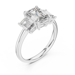 White gold lab grown diamond emerald cut three stone engagement ring, angled view