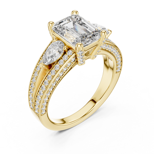 Yellow gold lab grown diamond emerald and pear three stone engagement ring, angled view