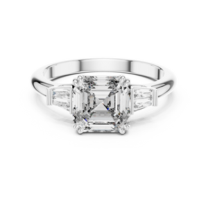 Diamond ring with a central emerald-cut diamond and baguette side stones on a white background