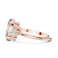 Rose gold ring with a pear-shaped diamond on a white background