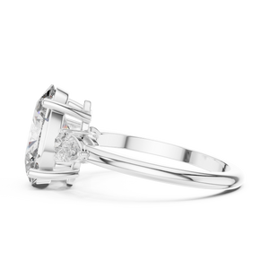 A side view of a luxury three-stone lab-grown diamond engagement ring in solid white gold, showcasing a 2.75 carat oval-cut center diamond and a brilliant pear-cut side stone on a clean background.