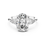 A front close-up view of a luxury three-stone lab-grown diamond engagement ring in solid white gold, highlighting a brilliant 2.75 carat oval center diamond and two pear-shaped side stones.