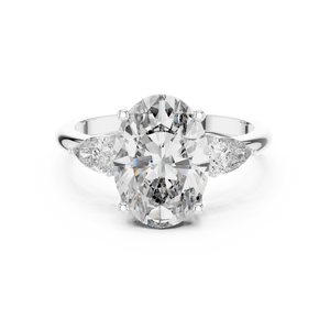A front close-up view of a luxury three-stone lab-grown diamond engagement ring in solid white gold, highlighting a brilliant 2.75 carat oval center diamond and two pear-shaped side stones.