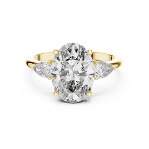 A front close-up view of a luxury three-stone lab-grown diamond engagement ring in solid yellow gold, highlighting a brilliant 2.75 carat oval center diamond and two pear-shaped side stones.