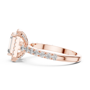 Low angle side view of rose gold emerald cut engagement ring showing halo and pave band