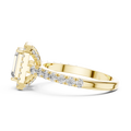 Low angle side view of yellow gold emerald cut engagement ring showing halo and pave band