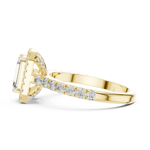 Low angle side view of yellow gold emerald cut engagement ring showing halo and pave band