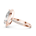 Side view of a pear-cut diamond engagement ring with a hidden halo in rose gold