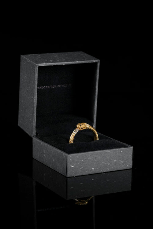 A black ring box with an engagement ring inside