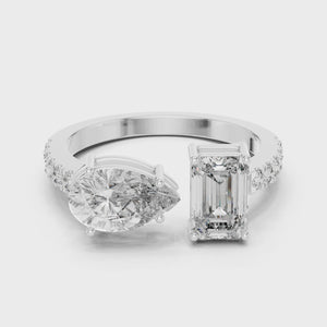 A video showcasing a luxury Toi et Moi lab-grown diamond engagement ring crafted in solid white gold, highlighting a 0.86 carat emerald-cut diamond and a 1.00 carat pear-shaped diamond on a pavé accented open band.