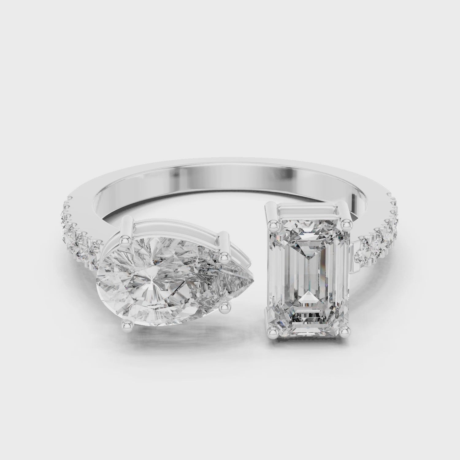 A video showcasing a luxury Toi et Moi lab-grown diamond engagement ring crafted in solid white gold, highlighting a 0.86 carat emerald-cut diamond and a 1.00 carat pear-shaped diamond on a pavé accented open band.