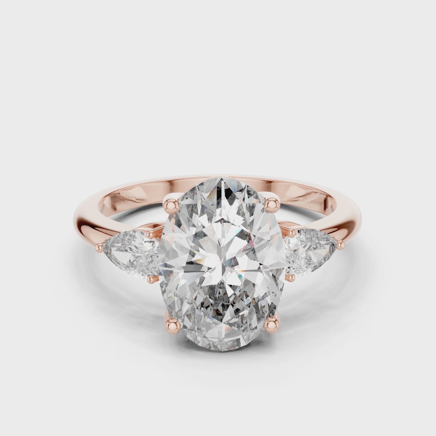 A stunning three-stone lab-grown diamond engagement ring in 14k rose gold, featuring a massive 2.75 carat oval-cut center diamond flanked by two brilliant pear-cut side stones on a clean white background.
