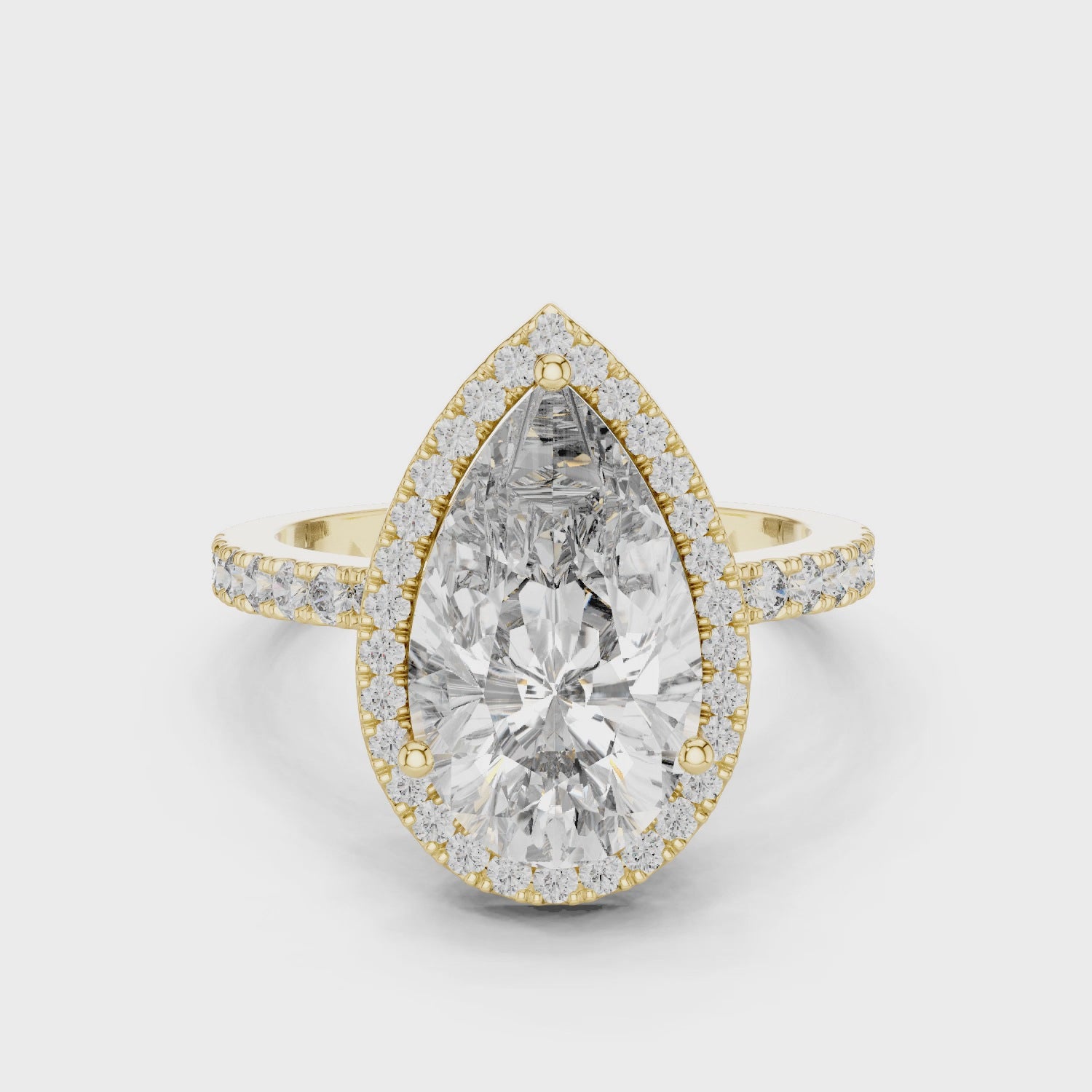 360-degree view of a pear-cut diamond halo engagement ring in yellow gold