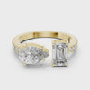 Create alt text for this video showcasing a luxury Toi et Moi engagement ring in solid yellow gold, featuring a 0.86ct emerald-cut diamond paired with a 1.00ct pear-cut diamond on a pavé-accented open band.